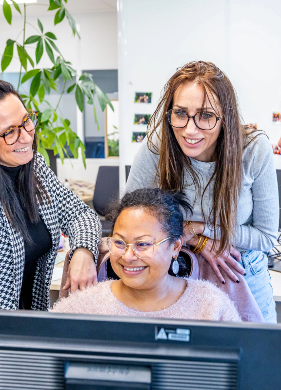 groupe de femmes devant un ordinateur qui échangent